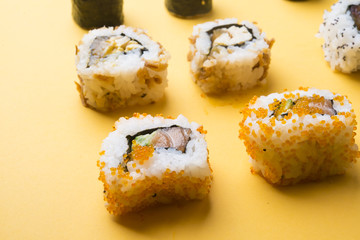 Various kinds of sushi food served on yellow blackground