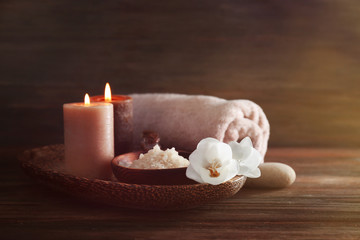 Spa set with sea salt, exotic flowers and candles on wicker tray