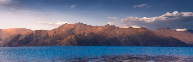 Fototapeta na wymiar india, It is 134 km long and extends from India to Tibet. Leh, Jammu and Kashmir, ladakh, Pangong tso (Lake) with blue sky in background. It is huge lake in Ladakh, scenic