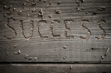 Word success carved in wood, word success on an old wooden board