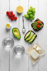 Avocado sandwiches with vegetables on wooden background