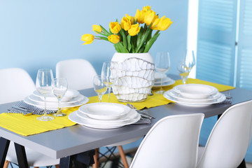 Table served with dishes and a bouquet of tulips
