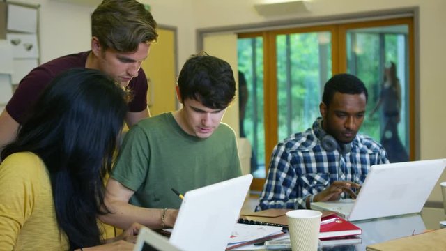  Young group of college students working together on a project