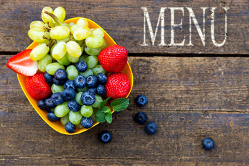 delicious fresh fruits on a wooden table, word menu