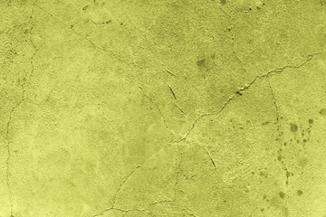 gelbe Wand mit Rissen und Flecken im Beton
