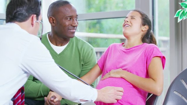  Pregnant woman going into labour is supported by her partner & medical staff