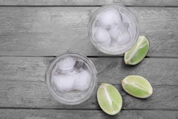 Glasses of water and sliced lemon on wooden table, top view