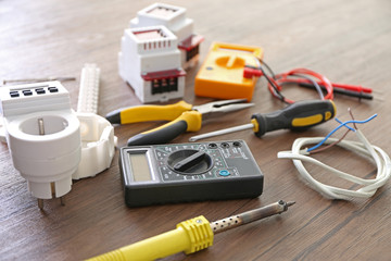 Different electrical tools on wooden table, top view