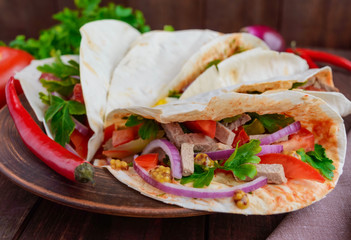 East pita bread with various fillings (meat, salami, egg, cucumber, parsley, tomato, chili pepper, Dijon mustard). Taco.