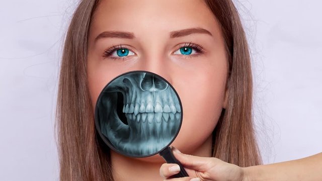 Roentgen screening with a manifying glass, face of a young woman