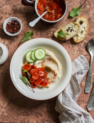 Healthy vegetarian lunch - bean puree with tomato sauce, homemade bread on a stone background. Top view