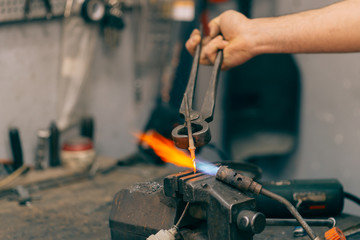 Metalworker working with torch and repair metal. Selective focus and small depth of field.