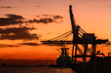 Fototapeta na wymiar Silhouette of container cargo and crane bridge