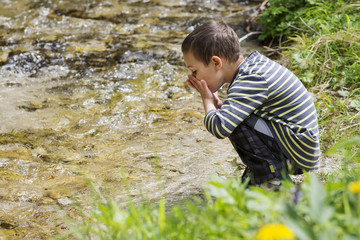 Child drinking clean river water