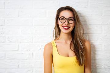 Happy Summer Hipster Girl in Glasses at White Wall
