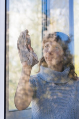 Obraz premium young woman washing window in the room