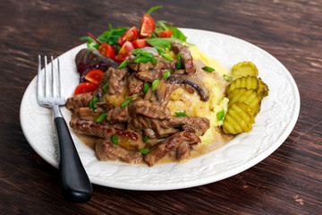 Beef Stroganoff with mashed potatoes and some vegetables.