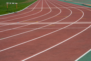 The running ways at the stadium with artificial coating of rubber and grass borders 