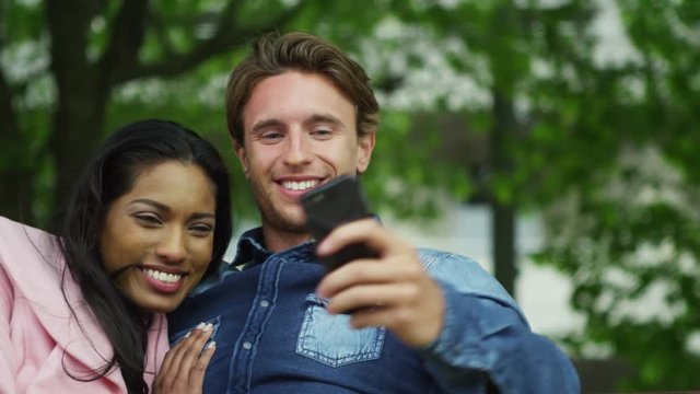  Romantic mixed ethnicity couple pose for a selfie in the park