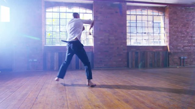  Asian martial artist training alone, practising moves with shaolin whip chain