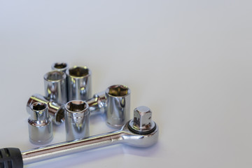 Set of sockets and ratchet. Mechanic tools in very soft focus. Isolated horizontal photo.