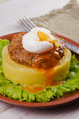 Beef and pork patty with poached egg, smashed potato and lettuce