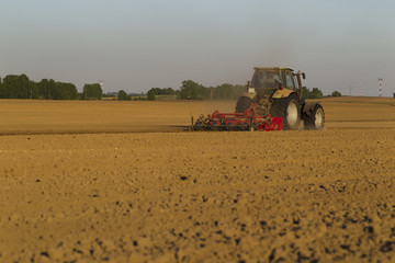 The tractor in the field on agricultural operations