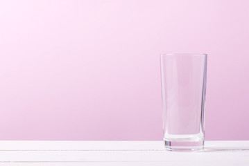 empty glass on a table on a pink background