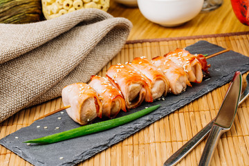 grill meat on a wooden skewer with green onions