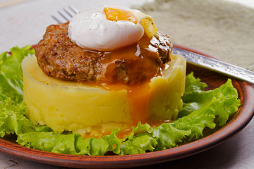 Beef and pork patty with poached egg, smashed potato and lettuce