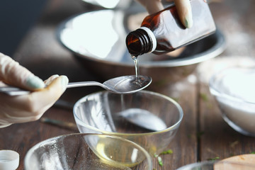 Preparation of bath bombs. Ingredients and floral decor on a wooden vintage table.