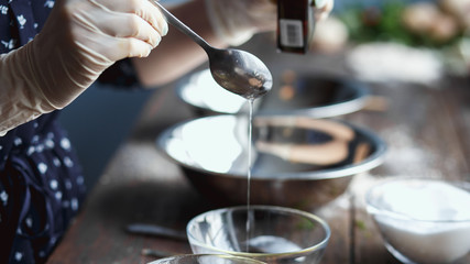 Preparation of bath bombs. Ingredients and floral decor on a wooden vintage table.