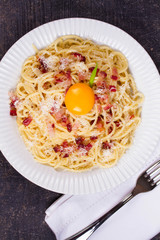 Carbonara pasta with raw egg, bacon and parmesan cheese. Overhead View