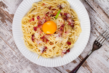 Carbonara pasta with raw egg, bacon and parmesan cheese. Overhead View