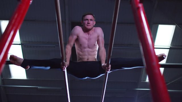  Professional male gymnast training on parallel bars at the gym