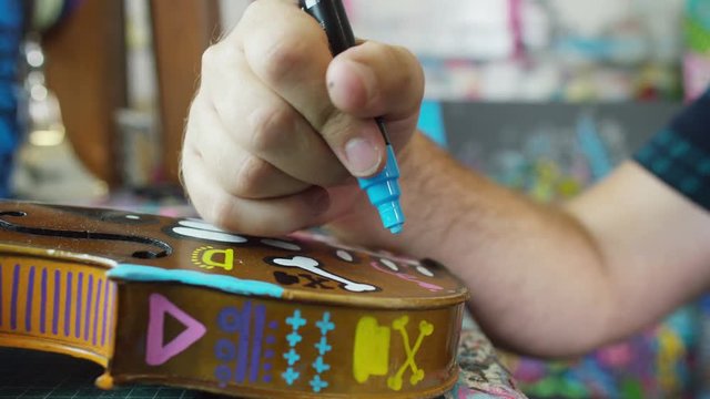  Modern graphic artist at work, putting an original design onto a violin