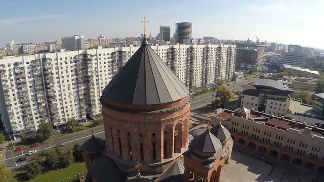 Aerial shot of Orthodox church in the city, it located in housing area next to the road