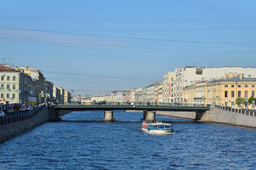 Obraz premium River boat sails under Semenovsky bridge over Fontanka