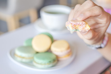  French colorful macaroons sweet dessert and with a cup of tea.