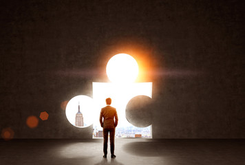 Obraz premium Businessman looking at puzzle hole