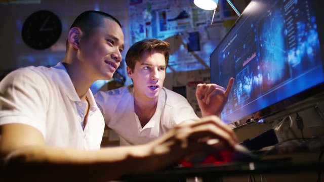  Young creative computer design team working together in dark office.