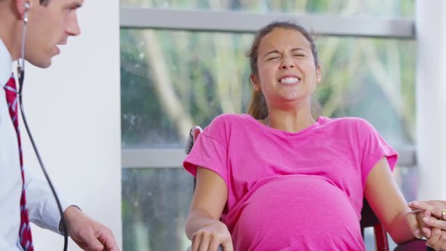  Pregnant woman going into labour concentrates on her breathing