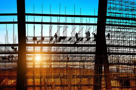 Silhouette of construction workers on scaffolding