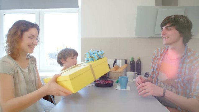 Young Man surprising his girlfriend with a gift