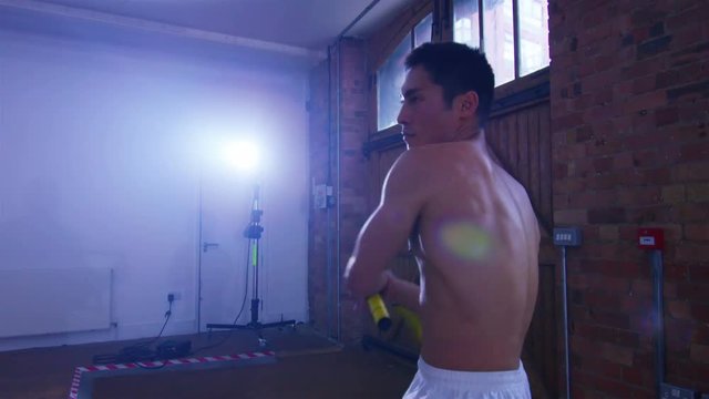  Young Asian martial artist training alone, practising his moves with nunchaku