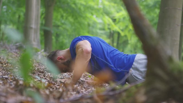  Young fit man working out in the woods