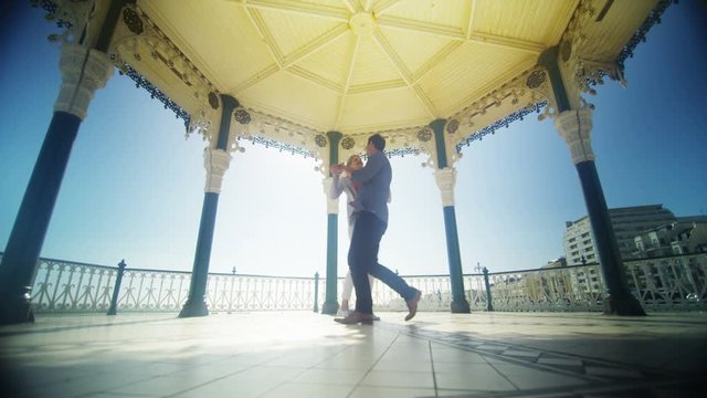  Attractive couple having fun together, dancing in bandstand in summer
