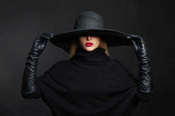 Beautiful woman in hat and leather gloves.halloween witch