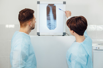 two yound doctors examining a x-ray film at the diaphanoscope