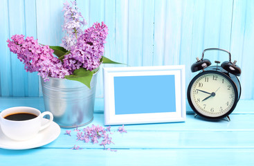 Fototapeta na wymiar Photo frame wooden background morning alarm clock gentle blue tone lilac purple coffee 